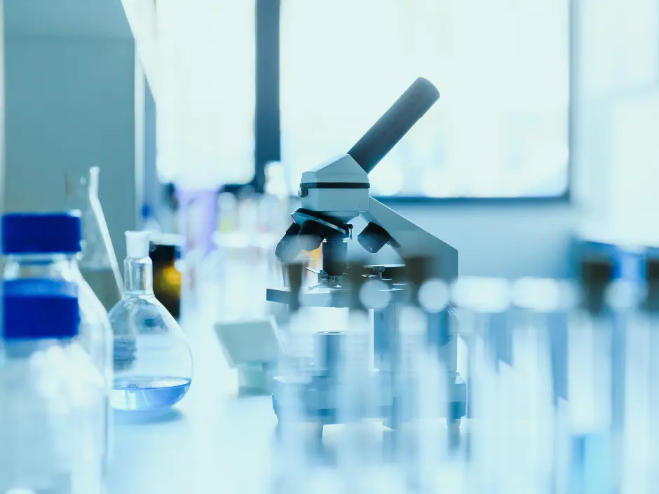 Mikroskop otoczony szkłem laboratoryjnym.